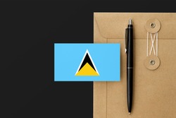 Saint Lucia flag on craft envelope letter and black pen background. National invitation concept. Invitation for education theme.