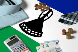 Lesotho flag on minimal money concept table. Coins and financial objects on flag surface. National economy theme.