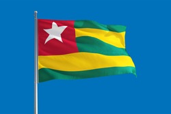 Togo national flag waving in the wind on a deep blue sky. High quality fabric. International relations concept.