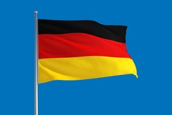 Germany national flag waving in the wind on a deep blue sky. High quality fabric. International relations concept.