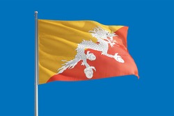 Bhutan national flag waving in the wind on a deep blue sky. High quality fabric. International relations concept.