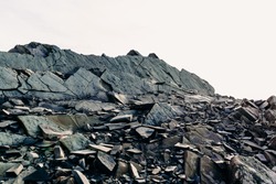 The top of a rocky mountain range. Gray flat stones. Rocky rock