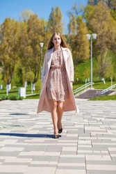 Full body portrait of a young beautiful blonde in pink coat