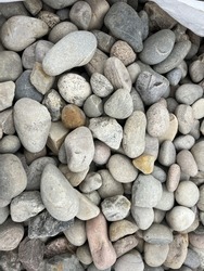 Close up area of beach gravel stone small rock pebble stones with different pattern and shapes smoothed by the sea on ocean shore uk outside environment in day light on cold bright day flat lay view