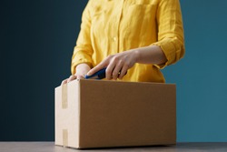 Woman opening a delivery box using a cutter