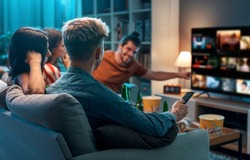Friends choosing a movie to watch together at home, video on demand concept
