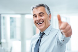Cheerful businessman thumbs up posing and smiling at camera