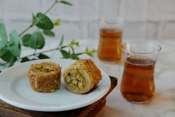 Baklava roll in selective focus, the sweet dessert pastry made of layers of filo filled with pistachio and thin noodle as a topping