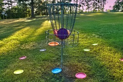 Disc golf basket with discs inside and outside.