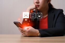 Business women select bad face emoticon on virtual touch screen at smartphone. Bad review, bad service dislike bad quality, low rating, social media not good