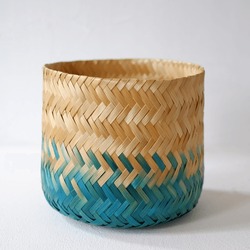 Natural cylinder bamboo basket craft coloring with splash of blue turquoise color. Woven bamboo handy craft isolated on white background.