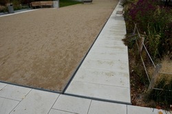 park square with gravel compacted paths and concrete sidewalk. a metal slot gutter is used for drainage. the sedignant solution without a grid is inconspicuous and subtle, rope fence,  flower bed