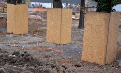 protection of tree trunks on a construction site. the trees in the alley must not be damaged and the bark can be easily torn off and damaged irreversibly when the excavators and machines are moved.