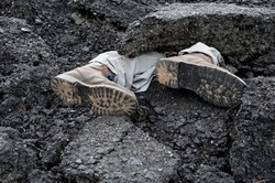 large pieces of asphalt partially cover the figure of a man under the rubble. skydiving backfill at construction site. rescue with the help of rescuers and specially trained dogs during field training