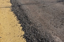 in the subsoil the asphalt road is covered with recycled asphalt crumb. the original yellow surface of the car park can be seen on the edge. a protective loose layer protects the existing new road