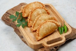Curry puff (kari pap ) or Pastel Goreng is Pastry Popular in Indonesia.
fried pastry with filling of sautéed vegetable , chicken and boiled egg. accompanied with  sauce or raw chilli pepper