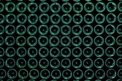 Many rows of green wine bottle bottom stacked-up on one another in pattern. Bases of stacked glass bottles. Green abstract backdrop with circular geometric shapes. Glass background. Seamless floor