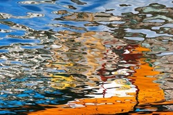Reflection detail of colored boats in the water canal, Aveiro, Portugal. bright reflected water. Abstract wave reflection. Fluid floor and colorful texture for background. Aqua, liquid