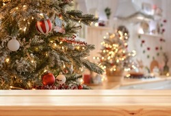 Empty wooden table on the background of christmas tree and blurred christmas kitchen, golden bokeh.Christmas background. Merry Christmas and Happy New Year! Ready for product montage.Mockup.
