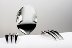 Spoon and two forks formed into conceptual figure