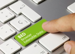 BED Browser Extensible Data Written on Green Key of Metallic Keyboard. Finger pressing key.