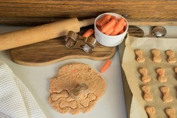 Making homemade healthy carrot dog treats. Dough  with cookie cutters.  