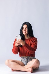 Attractive latin american girl using her mobile phone. young woman creating content for her social networks with her mobile device. Beautiful Colombian smiling and having fun with her cell phone.