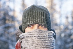 Portrait of a young man wrapped in a scarf. Cold