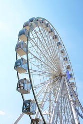 Ferris wheel against the blue sky. Modern Ferris wheel.
