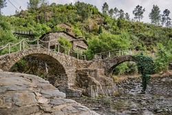 Schist path, two stone bridges over the Chãs stream and the Piodão stream, hill with typical houses in Foz de Égua, Arganil PORTUGAL