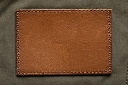 Blank brown leather label, macro close up. Leather patch with stitching