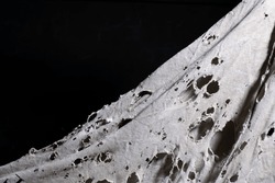 old dirty ragged cloth with holes, grunge damaged cloth veil on black background, ripped white fabric with many holes, copy space
