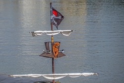 The upper part of the mast of a pleasure boat stylized as a pirate ship