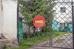 A sign forbidding entry into the courtyard hangs on a metal gate