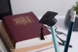 Graduate cap on the background of the holy bible. Spiritual education concept