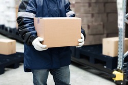 Worker carrying a goods box in a large frozen warehouse.Export-Import Logistics system concept.