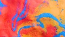 Mixing colours Blue, red and yellow creating pattern pink paint. close up relief, selective focus