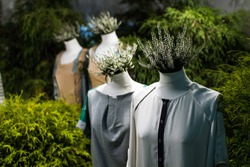 White mannequins , with heather on a dark green forest background. The concept of fashion, style, beauty, ecology, recycle, sustainability, reusing, concept. Zero and fabric waste, creative background