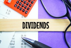 calculators, receipts, glasses with the word dividends