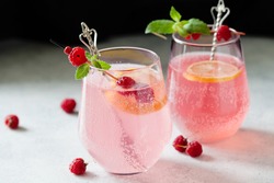 Sparkling pink raspberry lemonade on dark background, toned image