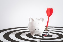 Bullseye is a target of business. Dart is an opportunity and Dartboard is the target and goal. Dart on center bullseye with piggy bank target of saving money.