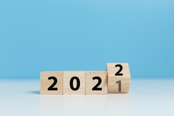 woodblocks cubes with a number 2021 change to 2022 blue background. new year 2021- 2022 concept. 