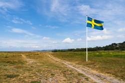 Swedish flag waving in wind with beautiful sky.