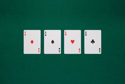 pikes card, cloves card, tiles card and hearts card on poker table green