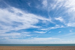 Empty beach with horizon, blue sky and wispy cloudscape. Aldeburgh, Suffolk UK. 