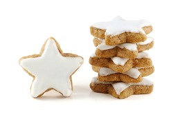 Christmas cookies, stack of cinnamon stars, a single one standing, in Germany called zimtsterne, close up isolated on white background