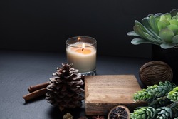 small wooden slats for display products is on the black wooden table decorate with scented candle and chirstmas ornaments during christmas new year celebration party theme