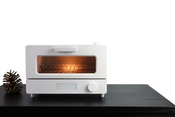 white modern design toaster oven , countertop or convection oven is on the black wooden table with pinecone background of white wall of the kitchen (clipping path included)