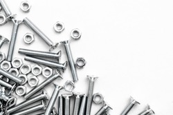 Top view of stainless steel bolts or iron nails on brigth white background with silver color.  Metal screws for use in sheet metal.
