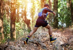 A man Runner of Trail and athlete's feet wearing sports shoes for trail running in the forest